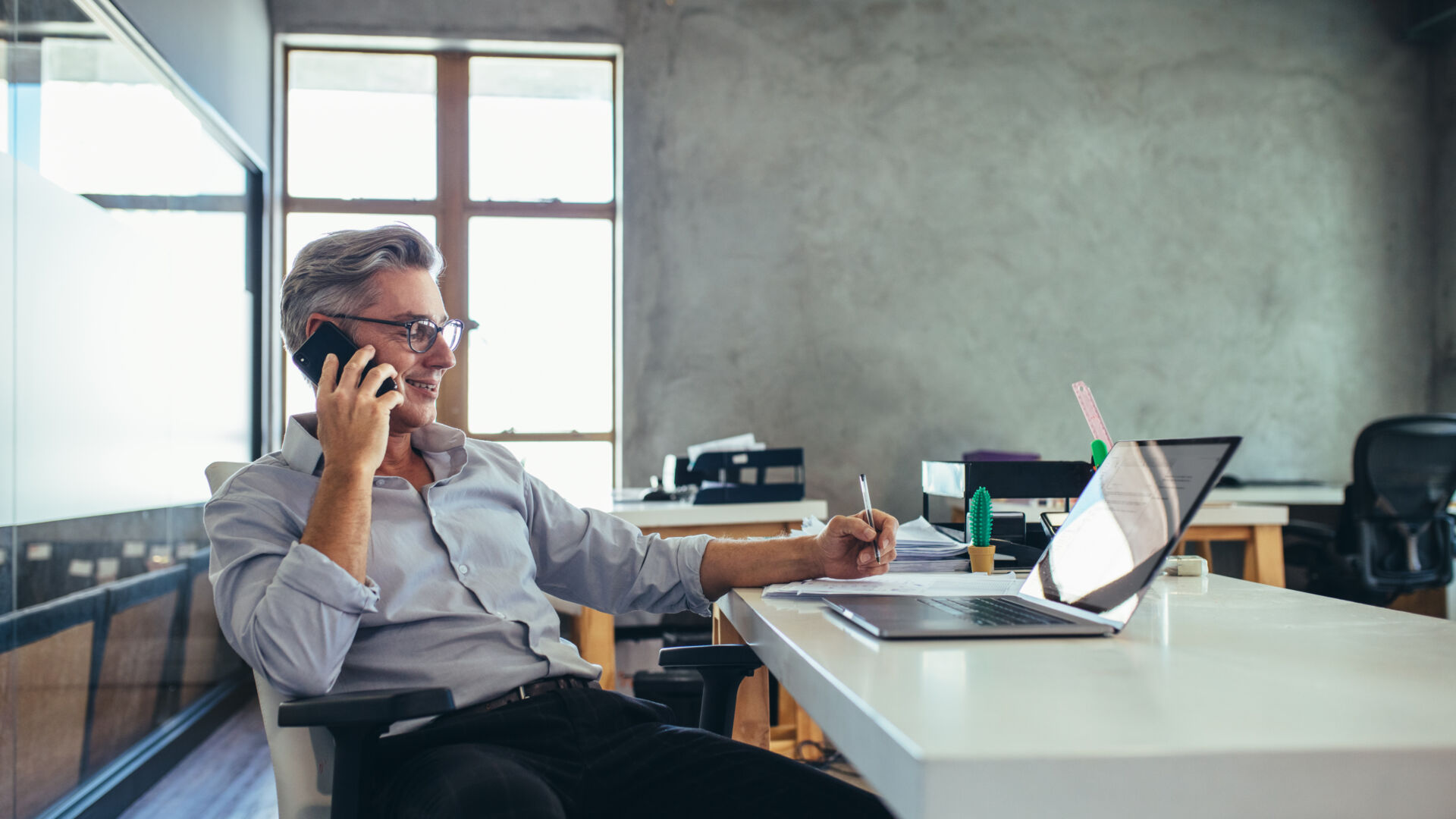 man on the phone while using a laptop