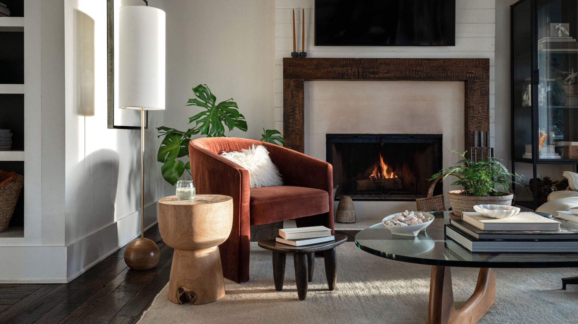 Living room with a lit fireplace, armchair, and coffee table