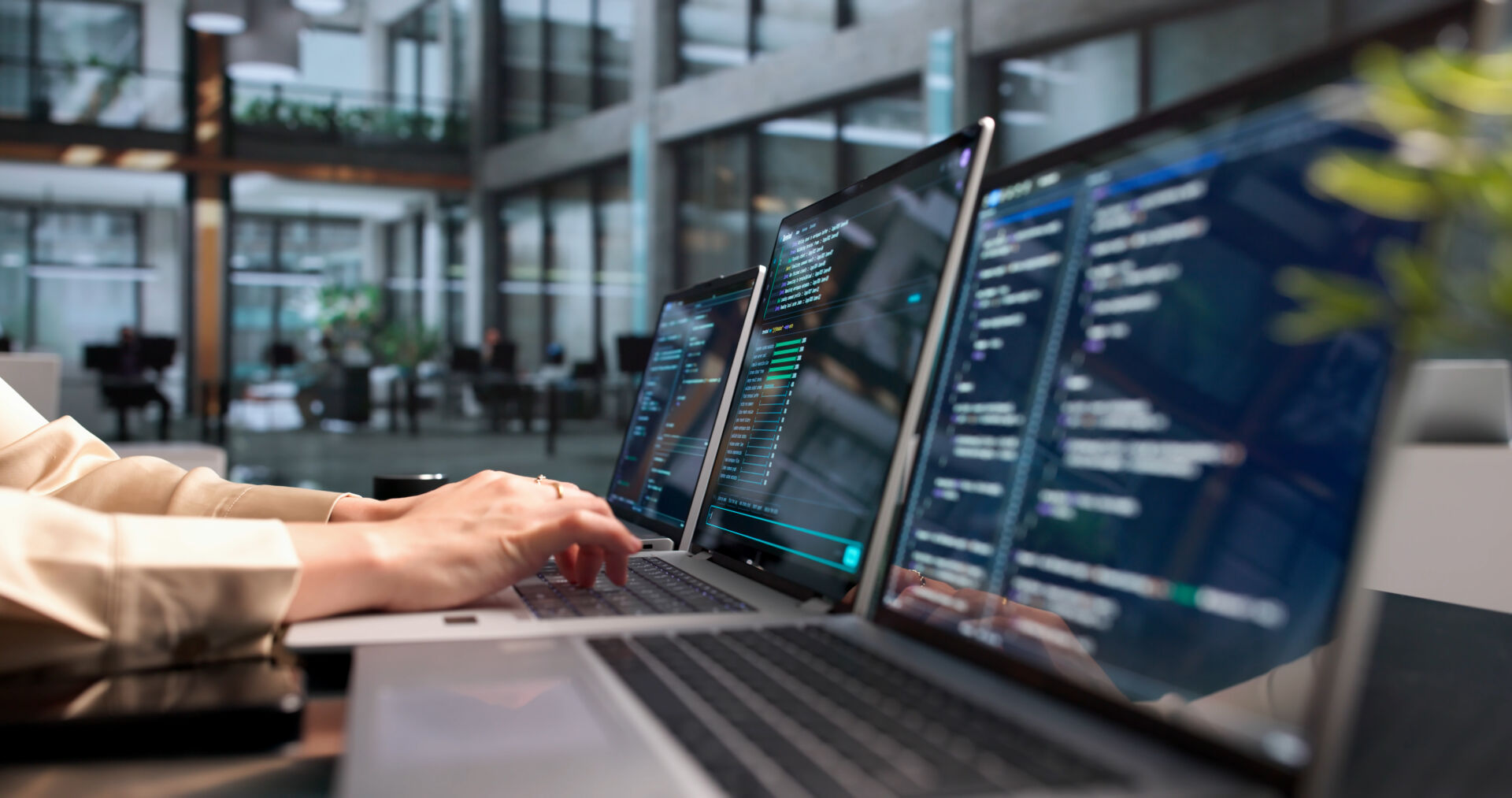 Hands on a laptop managing cloud-connected security systems in an office