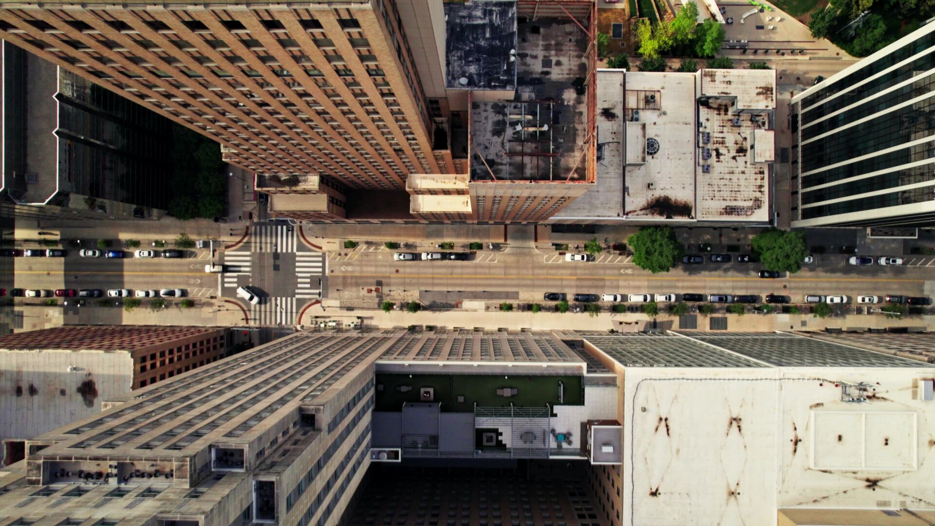 The drone flies between the skyscrapers. View of the street of the American city from above. Summer day