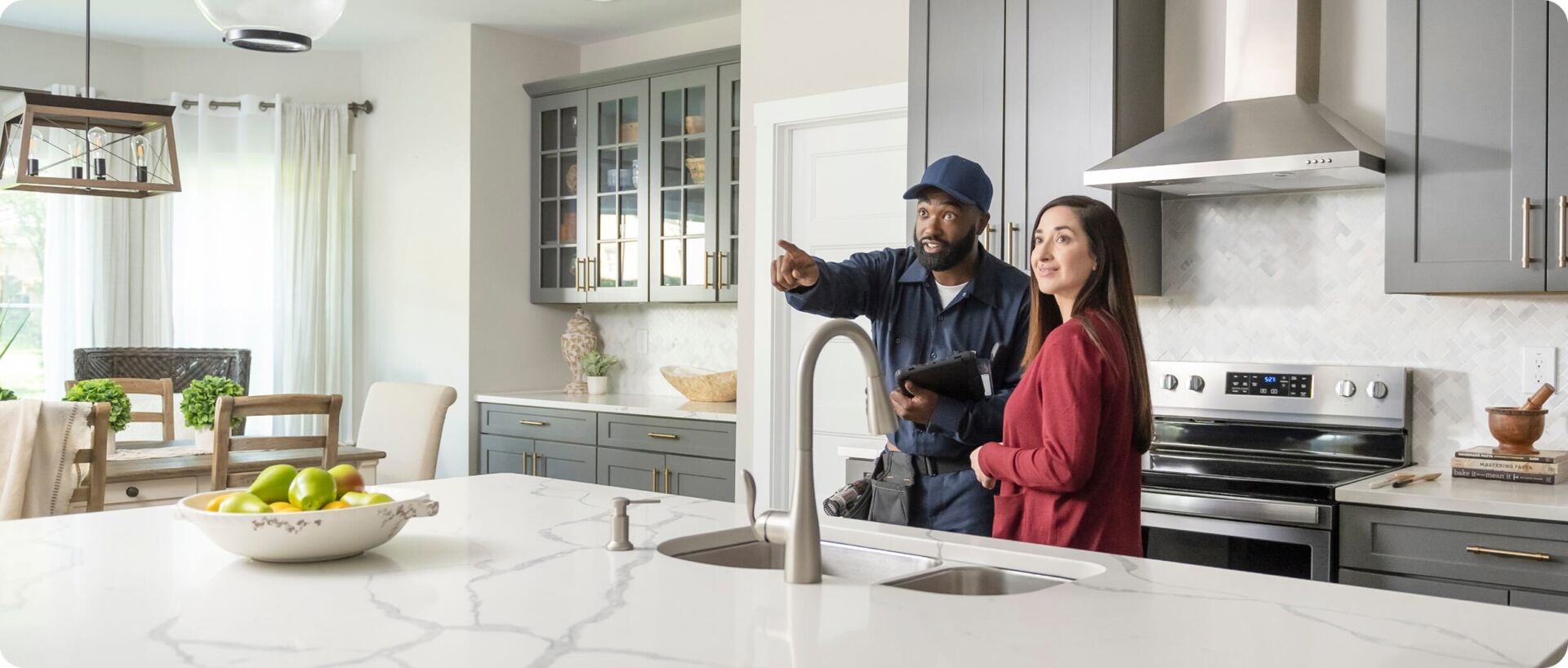 Technician homeowner kitchen pointing wide