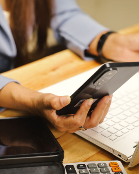 Reviewing a business activity report on a phone at a desk