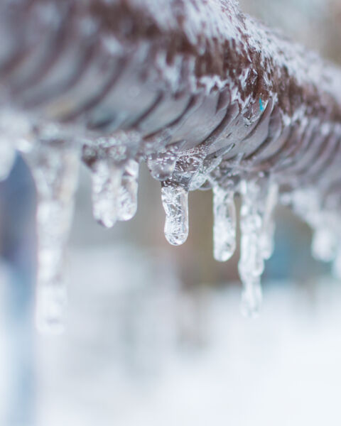 frozen icicles after rain on the pipe