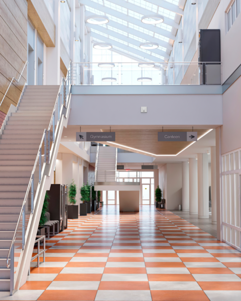 Bright school atrium with an open staircase and tiled corridor