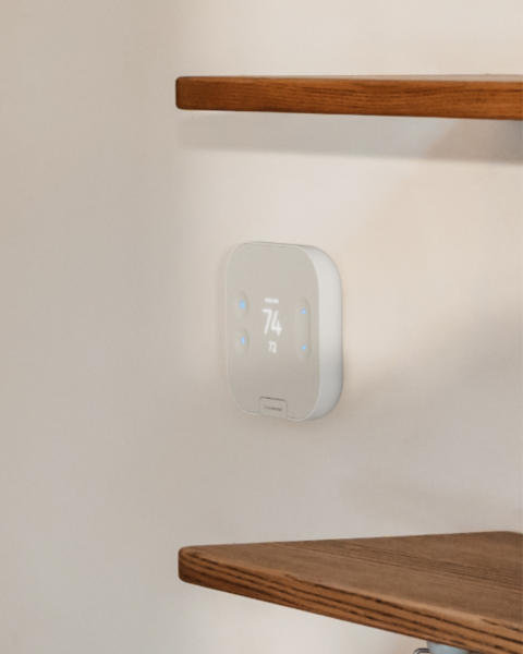 Smart thermostat mounted on an office wall for commercial energy management