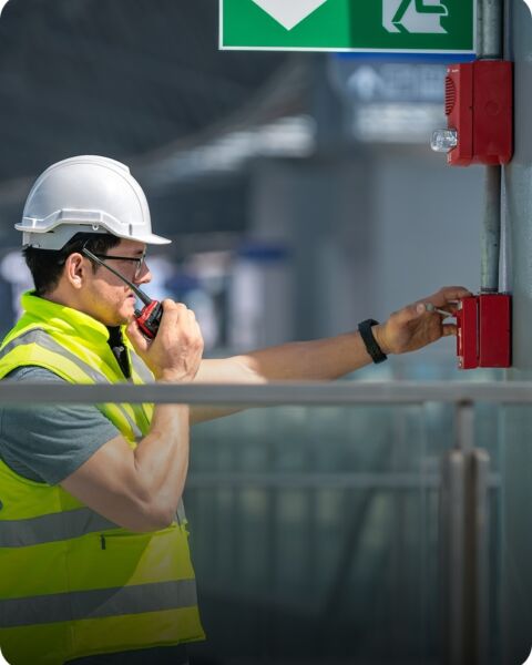 Worker in hard hat below exit sign