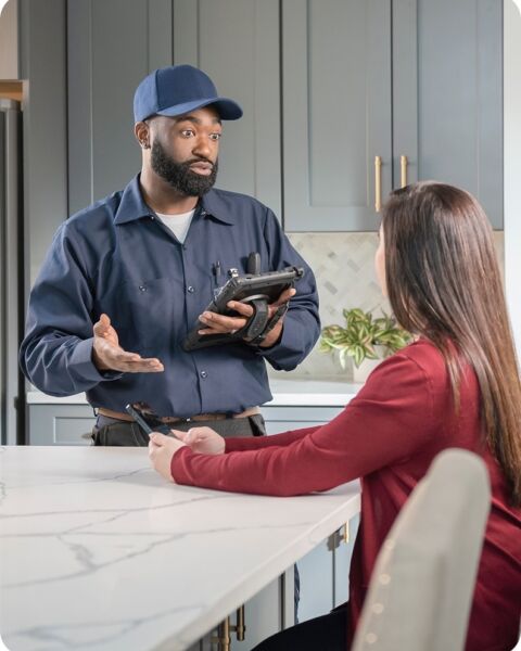 Technician explaining to homeowner kitchen