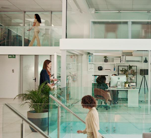 Employees moving through a glass-walled office corridor where every access event is logged