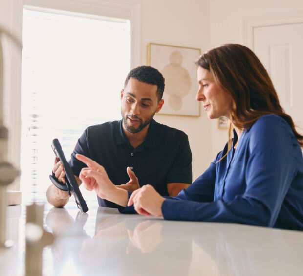 Two people reviewing a tablet together at a table