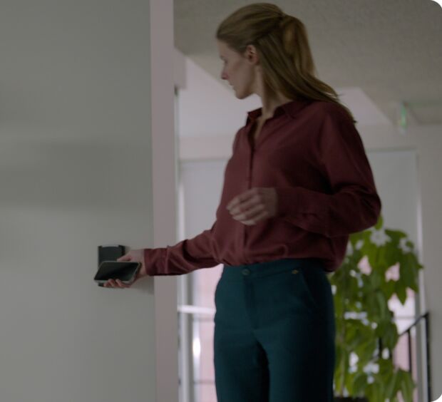Employee holding a phone to a reader to unlock an interior door
