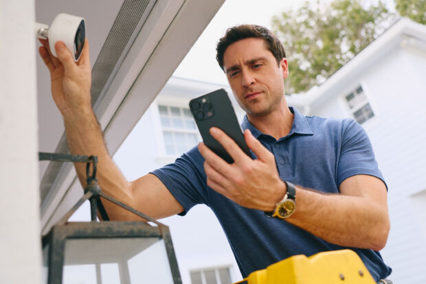 Man installing camera on a home